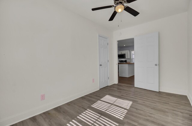 unfurnished bedroom featuring ceiling fan, a closet, and light wood-type flooring