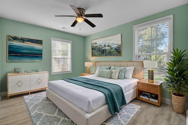 bedroom with light hardwood / wood-style floors and ceiling fan