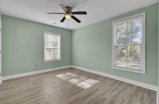 spare room featuring plenty of natural light, light hardwood / wood-style floors, and ceiling fan