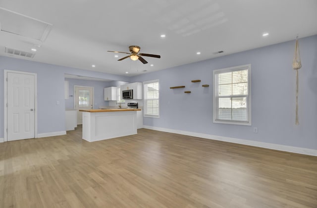 unfurnished living room featuring ceiling fan and light wood-type flooring