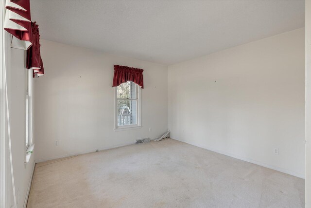 unfurnished room featuring visible vents and carpet floors