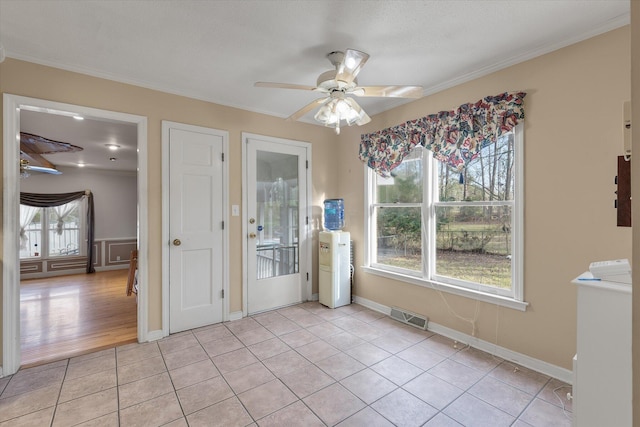 unfurnished dining area with light tile patterned floors, visible vents, ornamental molding, and a ceiling fan