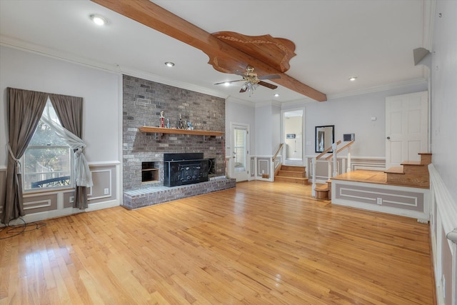 unfurnished living room featuring stairway, plenty of natural light, a brick fireplace, and beam ceiling