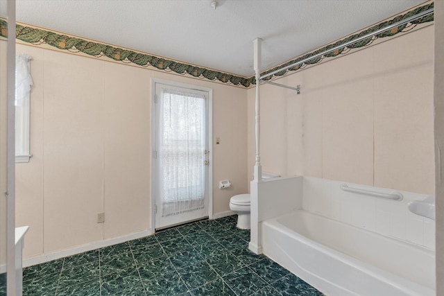 bathroom featuring baseboards, toilet, and a textured ceiling