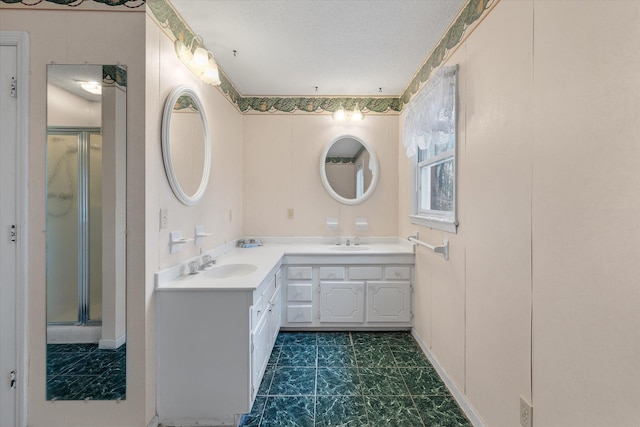 full bath featuring double vanity, a shower stall, and a sink