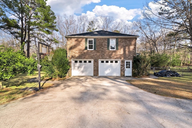 view of home's exterior with brick siding, an attached garage, aphalt driveway, and fence