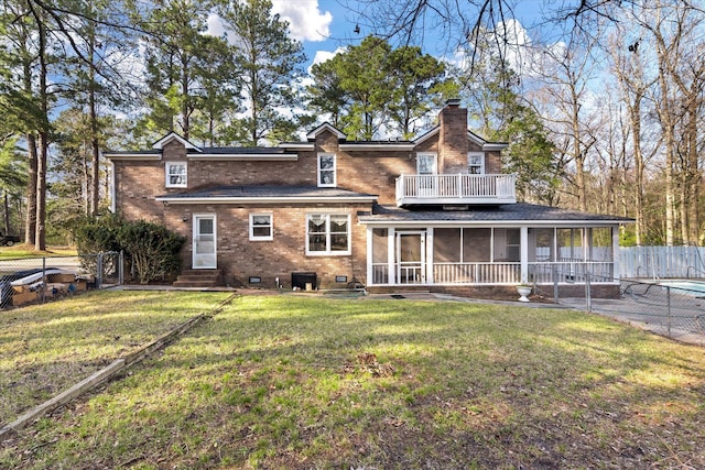 back of property featuring fence, a yard, a sunroom, brick siding, and a chimney