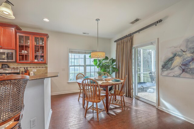 dining area with visible vents, baseboards, and dark wood finished floors