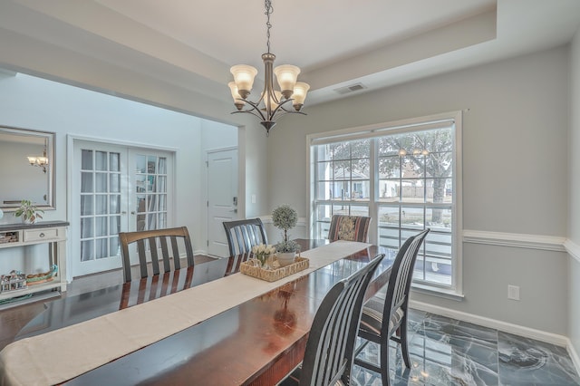 dining space featuring a notable chandelier, baseboards, visible vents, and french doors