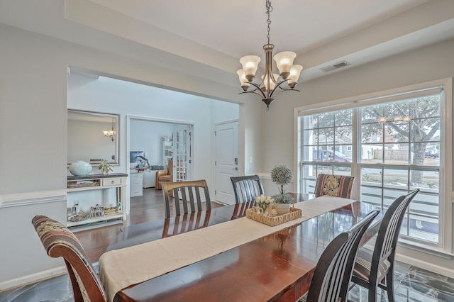 dining area featuring a chandelier, visible vents, baseboards, and wood finished floors