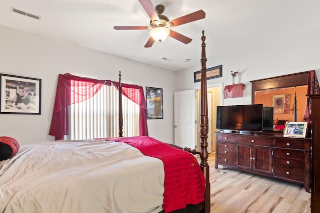 bedroom featuring light wood finished floors, visible vents, and a ceiling fan