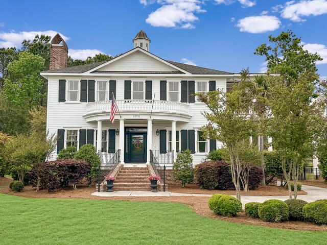 colonial house with a front yard and a porch