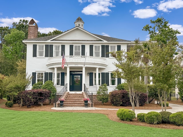 colonial house with a front yard and a porch