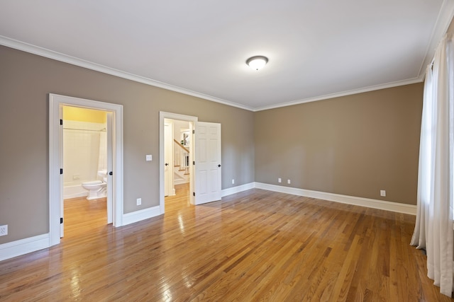 unfurnished bedroom with wood-type flooring, ornamental molding, and ensuite bath