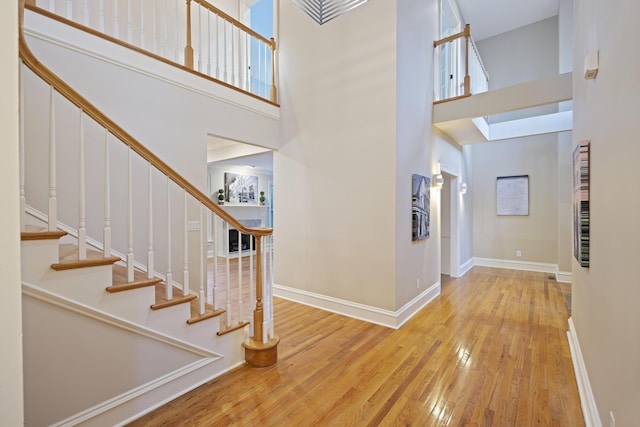 entrance foyer with a towering ceiling and light hardwood / wood-style floors