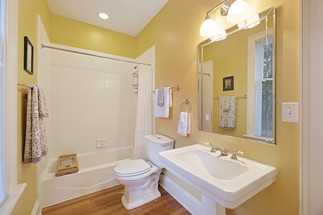 full bathroom featuring hardwood / wood-style flooring, toilet, shower / bathtub combination with curtain, and sink