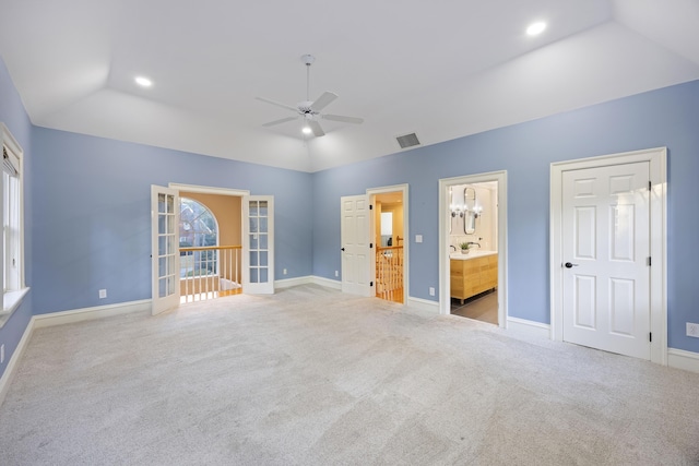 unfurnished bedroom with ensuite bath, ceiling fan, french doors, light colored carpet, and lofted ceiling