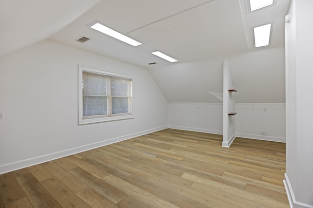 bonus room featuring lofted ceiling and light wood-type flooring