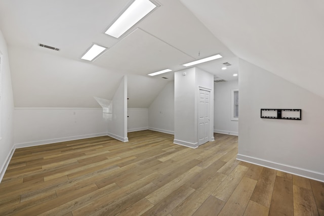 additional living space featuring light hardwood / wood-style floors and vaulted ceiling