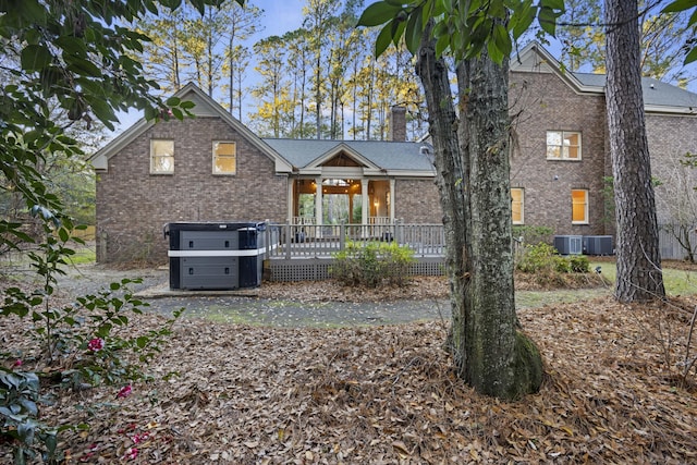 view of front of property with central air condition unit, a deck, and a hot tub