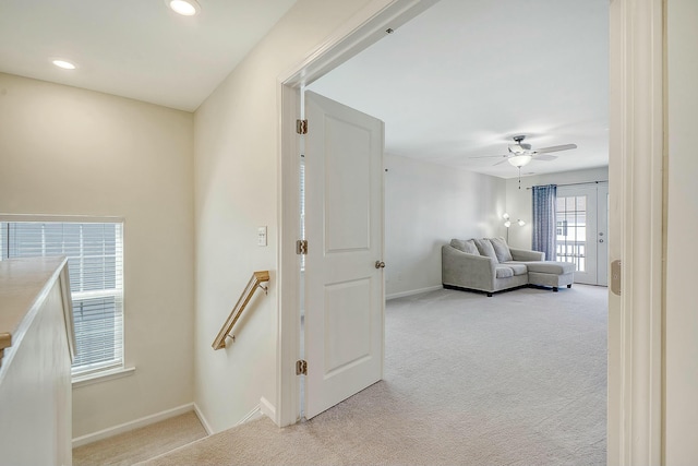 hallway featuring recessed lighting, baseboards, light carpet, and an upstairs landing