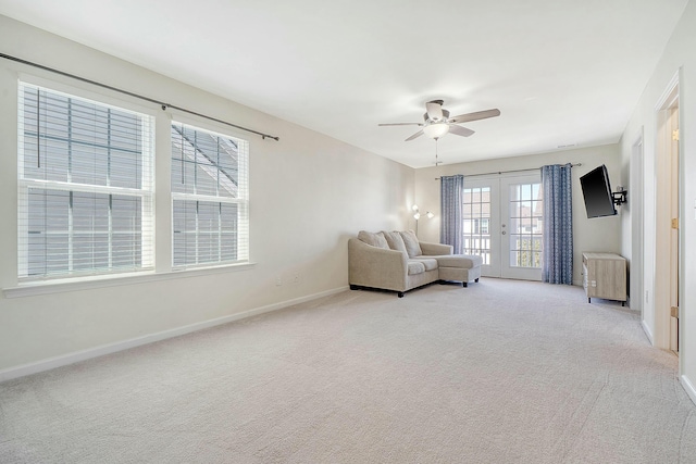 unfurnished room with light carpet, ceiling fan, french doors, and baseboards