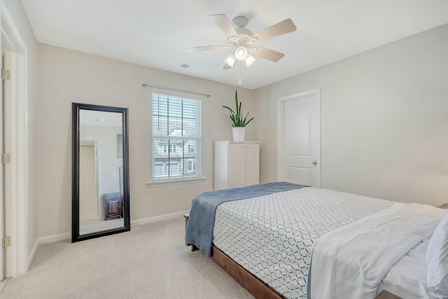 bedroom featuring a ceiling fan, visible vents, light colored carpet, and baseboards