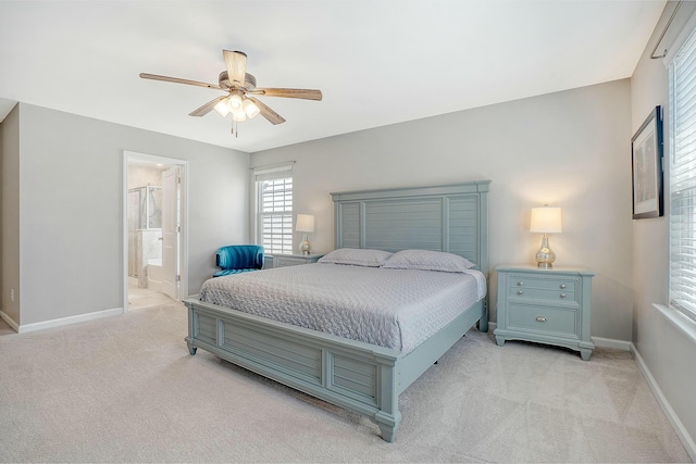 bedroom with baseboards, light carpet, connected bathroom, and a ceiling fan