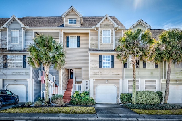 townhome / multi-family property featuring a garage, driveway, and stairway