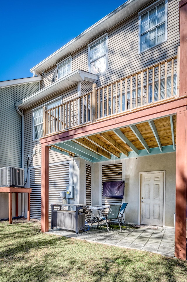 back of property with a yard and a patio area