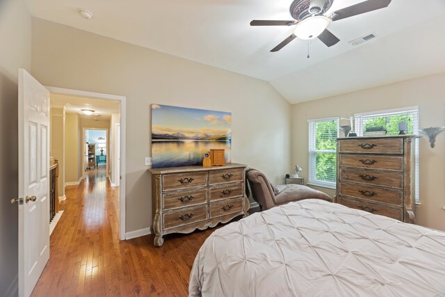 bedroom featuring hardwood / wood-style floors, vaulted ceiling, and ceiling fan