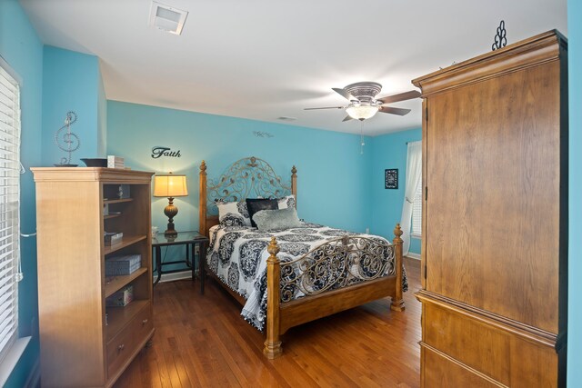 bedroom featuring dark wood-type flooring, ceiling fan, and multiple windows