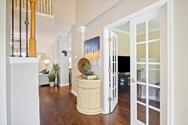 hall featuring dark hardwood / wood-style flooring, crown molding, french doors, and ornate columns