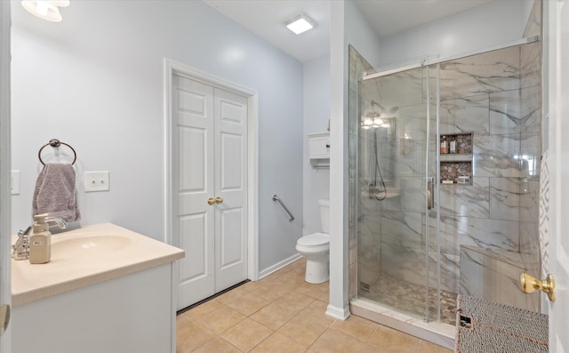 bathroom with vanity, a shower with shower door, tile patterned floors, and toilet