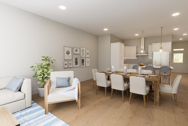 dining room with recessed lighting, light wood-style flooring, and baseboards