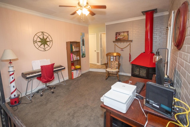 carpeted office space featuring crown molding, ceiling fan, brick wall, and a wood stove