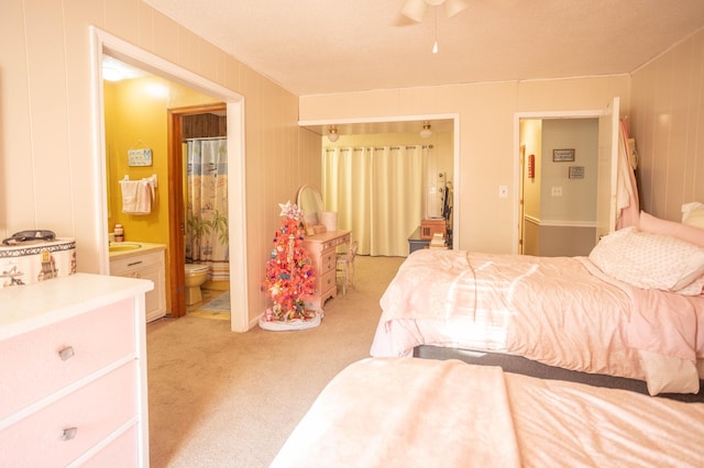 carpeted bedroom featuring sink and ensuite bath