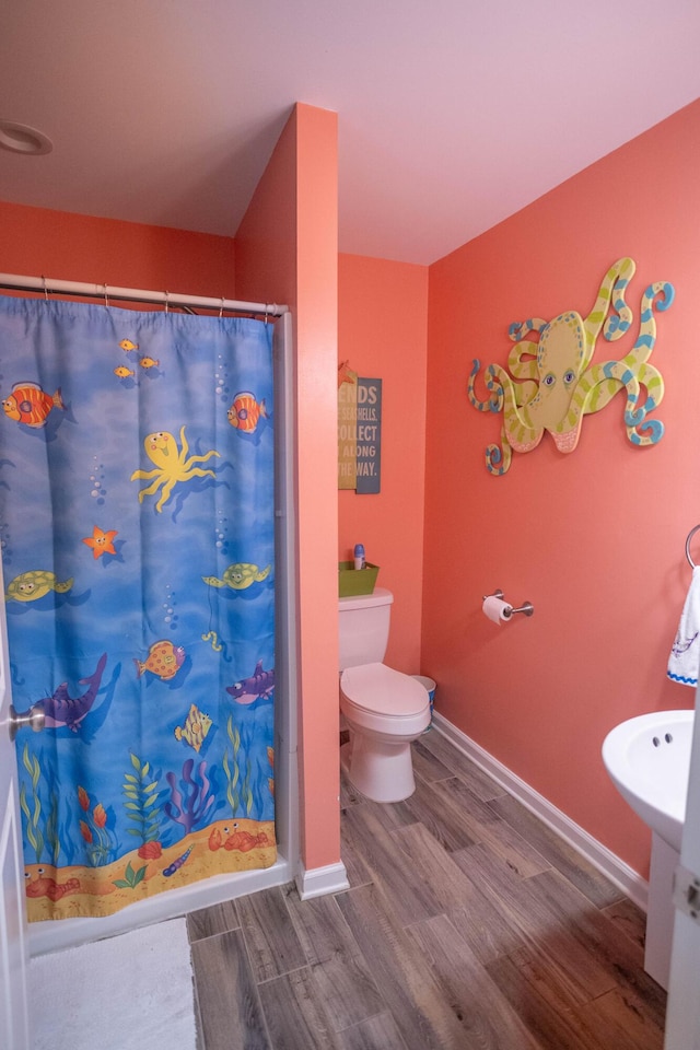 bathroom featuring hardwood / wood-style floors, toilet, and walk in shower