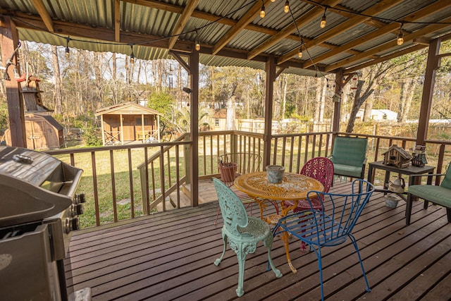 wooden terrace with a shed and a lawn