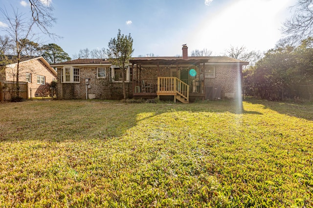 rear view of house featuring a yard and a deck