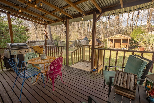 deck featuring a shed and a grill