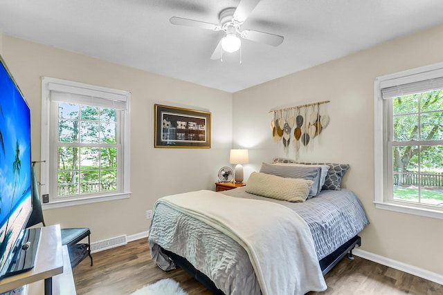 bedroom with baseboards, visible vents, and multiple windows