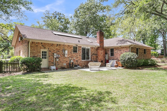 back of property featuring a patio, fence, a yard, and brick siding