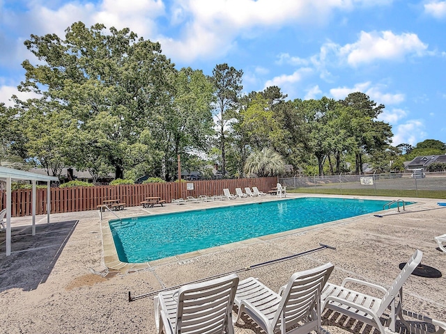 pool featuring fence and a patio area