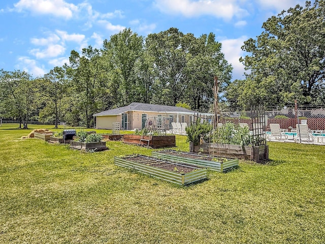 view of yard featuring fence and a vegetable garden