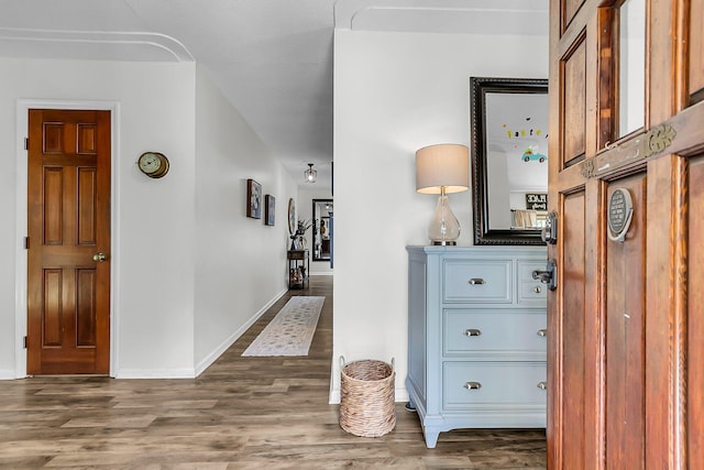 hall featuring baseboards and wood finished floors