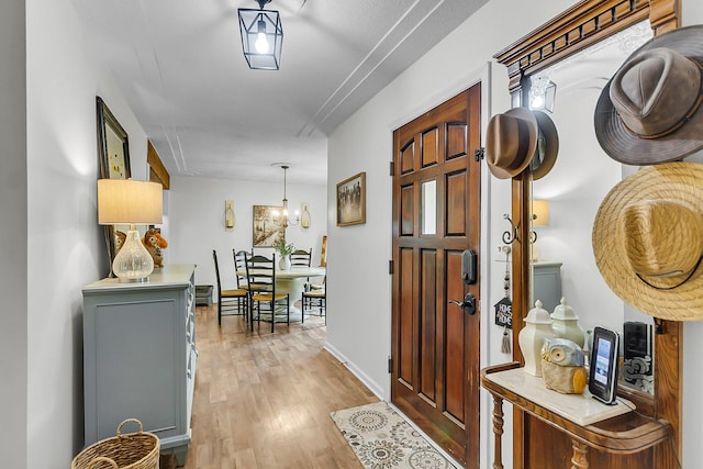 hallway with light wood-type flooring and baseboards