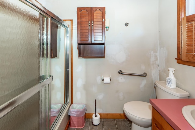 bathroom featuring tile patterned flooring, vanity, toilet, and walk in shower