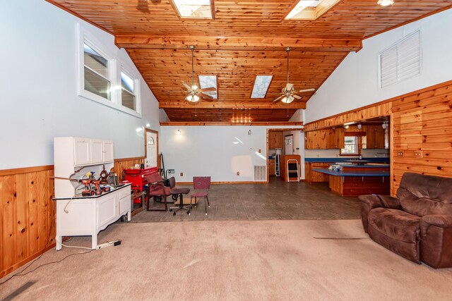 living room featuring a skylight, wood ceiling, light colored carpet, ceiling fan, and high vaulted ceiling