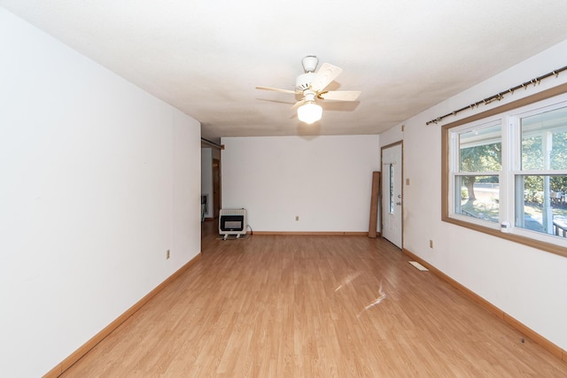 interior space featuring ceiling fan, light hardwood / wood-style floors, and heating unit